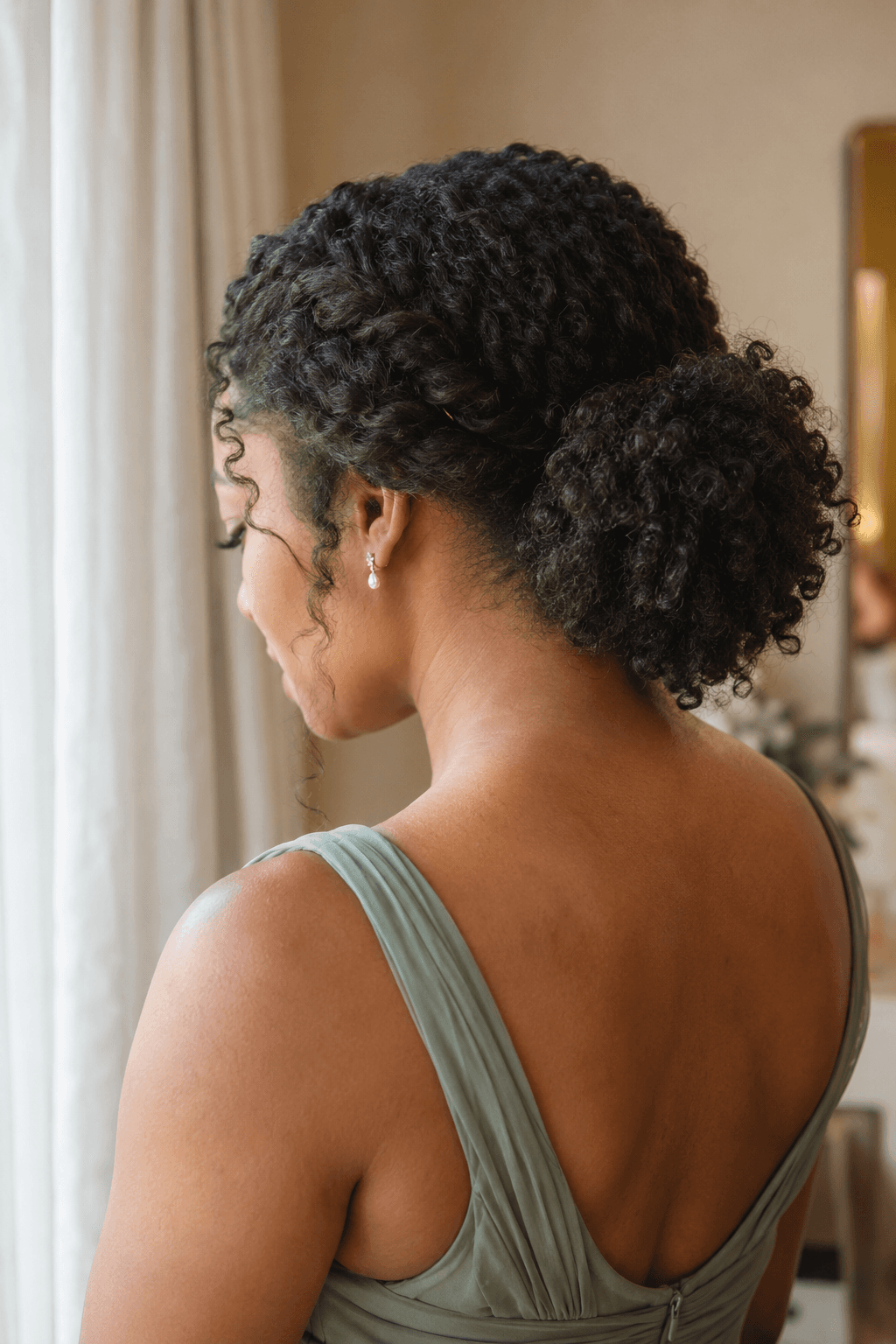 Bridesmaid hairstyle with natural curls and pinned twists